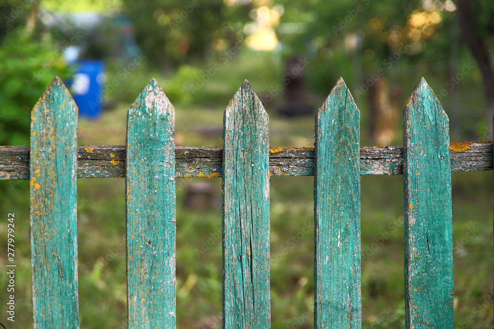 Background texture of old painted green paint wooden fence in the village. Cropped shot, horizontal, place for text, without people. Concept of construction and traditions.