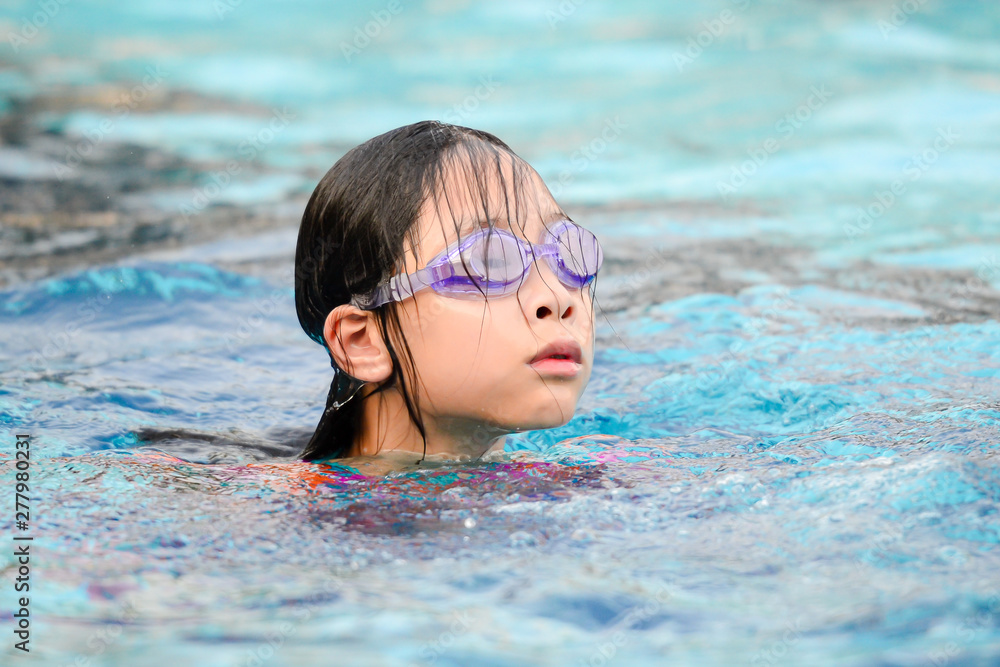 Asian girl wearing goggle and enjoying in pool, lifestyle concept.