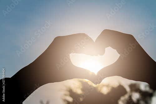 love shape hand silhouette at sunset