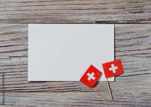  Switzerland, August 1. Federal holiday in honor of the Swiss Confederation. the concept of freedom, Alliance and Union. mini flags with sheets of white paper on wooden background. horizontal