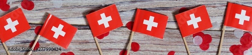 independence day Switzerland, August 1. Federal holiday in honor of the founding of the Swiss Confederation. day of the Confederacy. mini flags with confetti on wooden background. banner