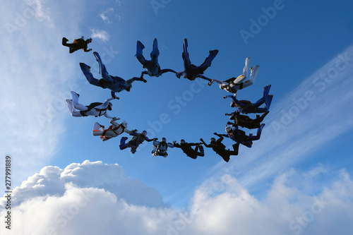 Formation skydiving. A group of skydivers is in the amazing sky.