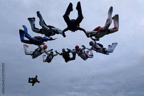 Formation skydiving in the cloudy sky.