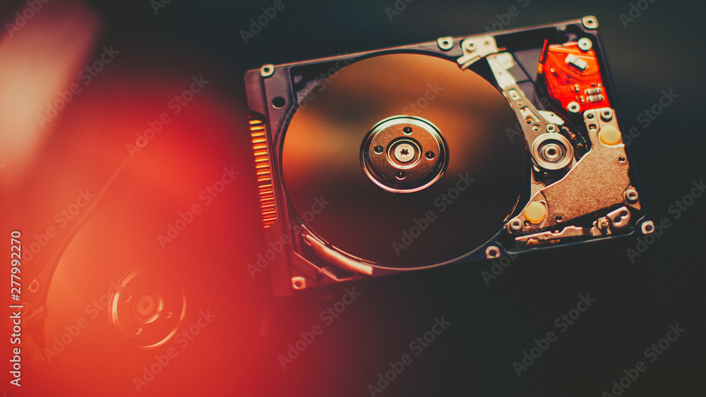 Computer engineering technology. Open disassembled hdd. PC, laptop  component. Red lens flare effect. Stock Photo | Adobe Stock