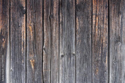 old wooden fence. Faded wooden planks with corrosion. Peeled wooden door of several boards. Old natural wooden board without paint.
