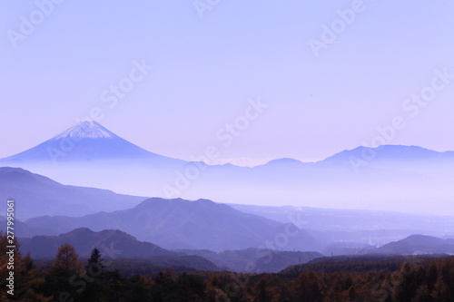 紅葉樹林の上にそびえ立つ富士山