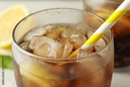 Glasses with cold cola and citrus on white cement background, closeup