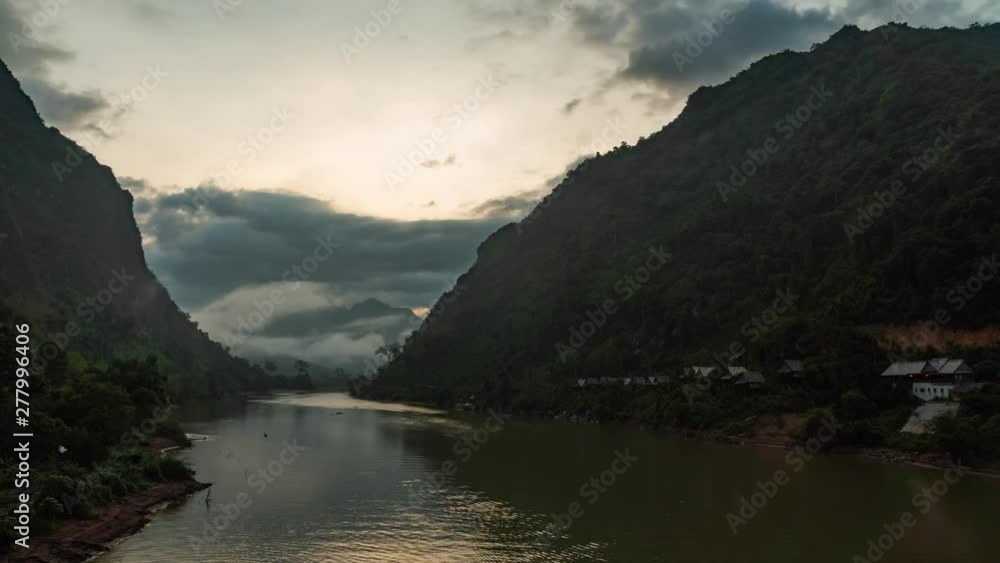 time lapse from Nong Khiaw bridge of Mekong river sailed by tradional boat. Mountain surrounded by clouds. Heavy fog cover the sky in the morning. Fisher man cross the river at sunrise. time lapse from Nong Khiaw bridge of Mekong river sailed by tradional boat. Mountain surrounded by clouds. Heavy fog cover the sky in the morning. Fisher man cross the river at sunrise.