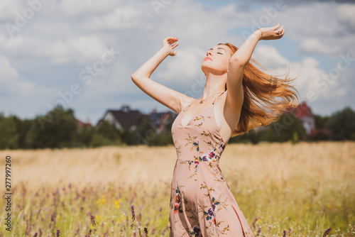 Freedom concept, elegant woman in long beige romantic dress at the field 