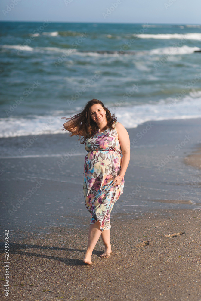 happy pregnant woman walking along sea shore happy pregnant woman walking along sea shore