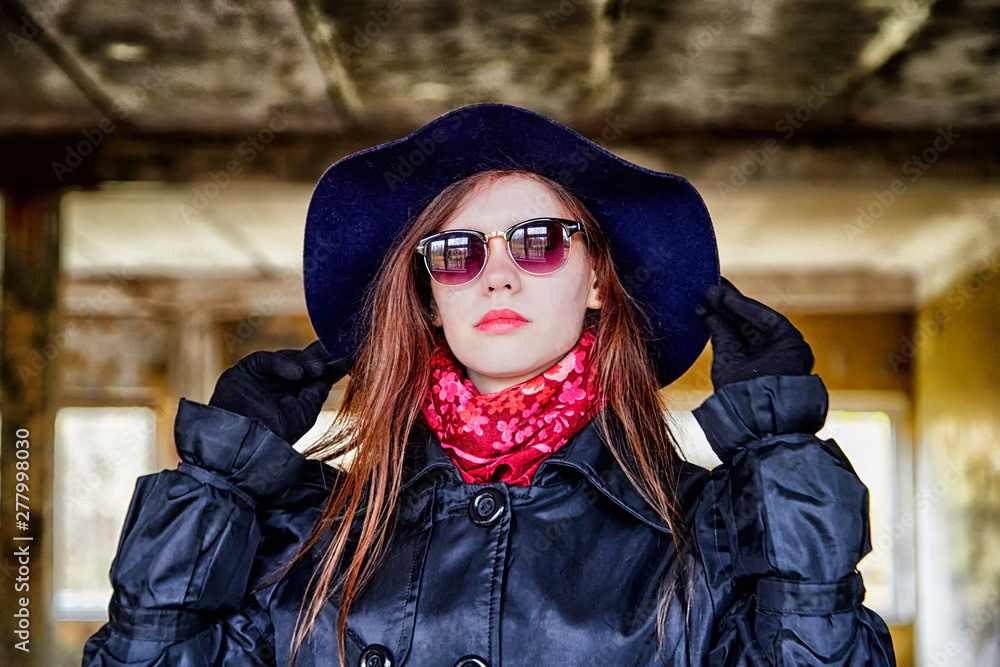 Girl in a black cloak and hat posing in an abandoned, ruined house. Unusual photo shoot Girl in a black cloak and hat posing in an abandoned, ruined house. Unusual photo shoot