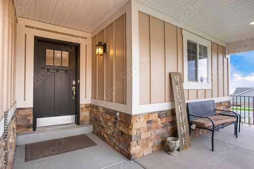 Entrance of a home with porch and glass paned wooden front door