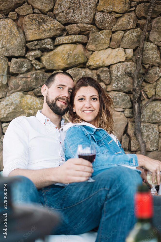 Young couple sitting on a terrace while bonding and enjoying a cup of wine Young couple sitting on a terrace while bonding and enjoying a cup of wine