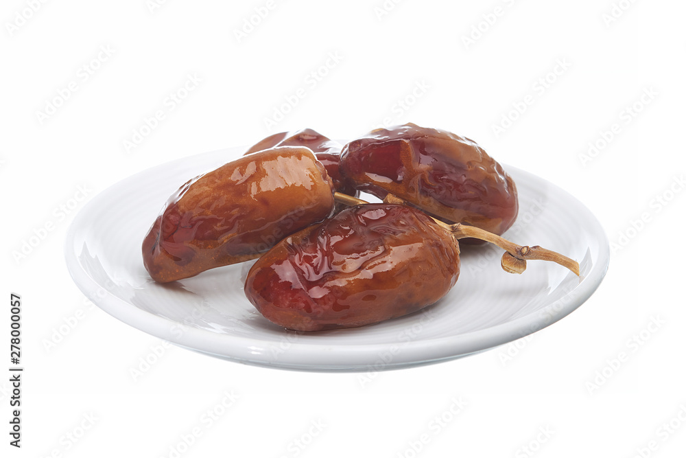 Dried date palm are shiny in ceramic dish isolated on white background.
