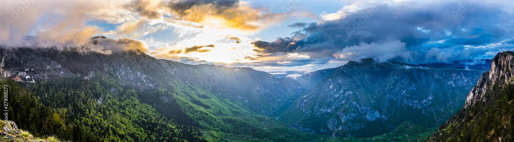 Obraz premium Montenegro, XXL panorama of orange sunset sky and clouds in dawning light over world famous tara river canyon nature landscape from summit of mount curevac in durmitor national park near zabljak