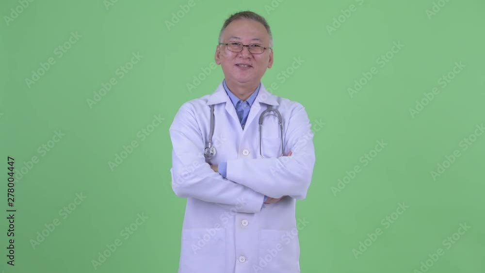 Happy mature Japanese man doctor smiling with arms crossed Happy mature Japanese man doctor smiling with arms crossed