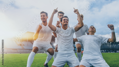 Fotografiet Captain of the Soccer Team Stands on His Knees Celebrates Awesome Victory, Makes YES Gesture Champion Team Joins Him