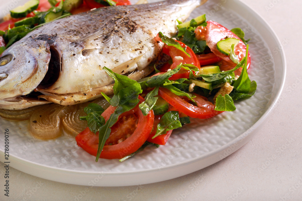 Baked dorado fish served with salad Baked dorado fish served with salad