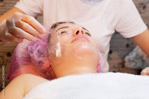 Young woman receiving facial epilation close up. Cosmetologist removes hair on face. Beauty salon, mustache depilation