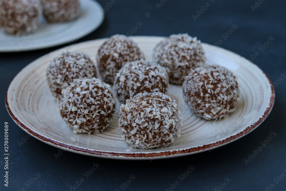 Curd balls with coconut shavings and chocolate chip cookies re located on a dark background, horizontal Curd balls with coconut shavings and chocolate chip cookies re located on a dark background, horizontal