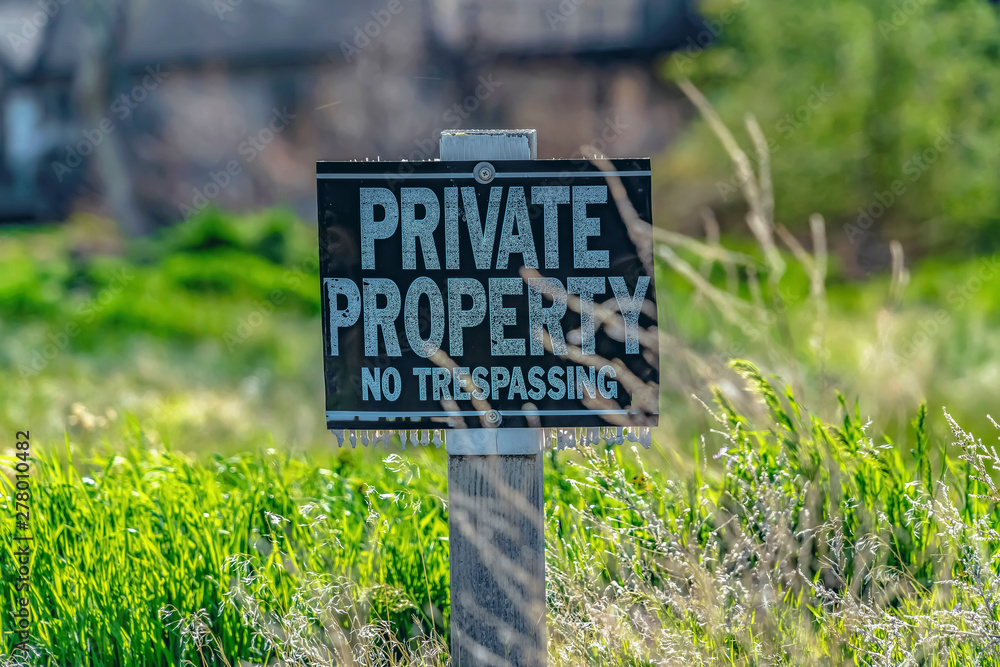 Close up of a Private Property No Trespassing sign on a sunny day