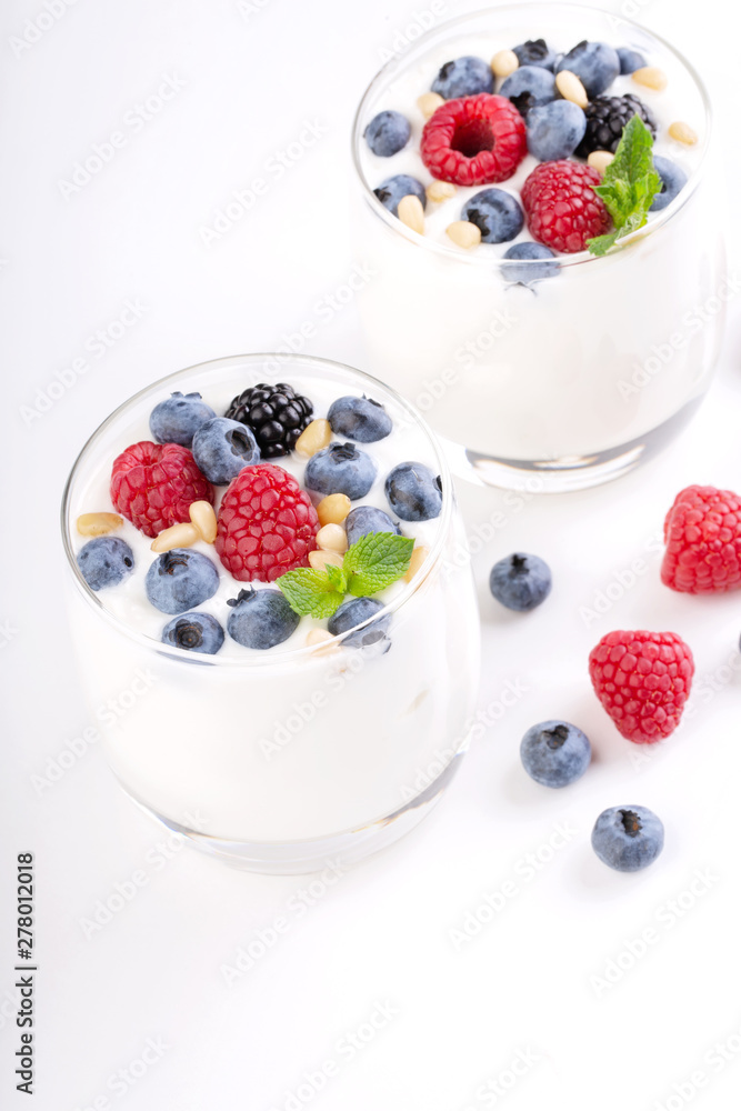 Two glasses of white yogurt with wild berries Two glasses of white yogurt with wild berries