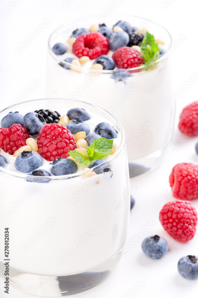 Two glasses of white yogurt with wild berries Two glasses of white yogurt with wild berries