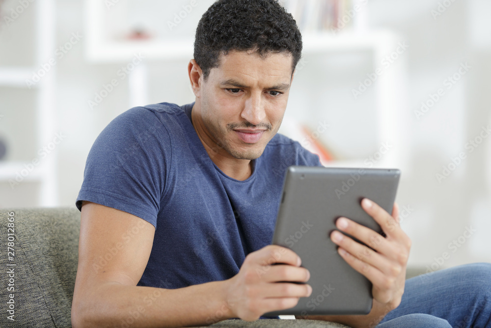 smiling man playing on digital tablet smiling man playing on digital tablet