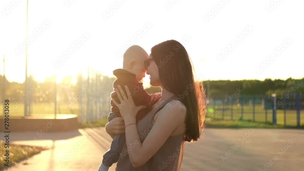 Mother plays with son near field at sunset. Slow mo Mother plays with son near field at sunset. Slow mo