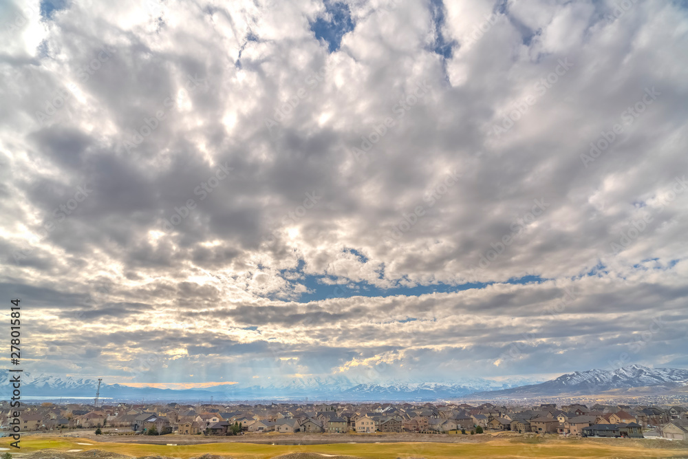 Panoramic view of cloud filled blue sky over houses on a vast valley