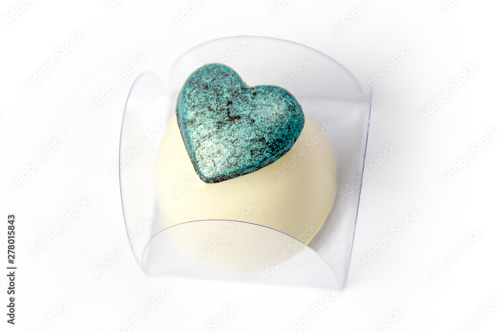 Fototapeta premium White chocolate candy stuffed with heart covered with edible blue paint as decoration.