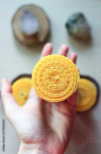 Handmade wax candle on light background.  Christmas decoration for holidays.  Craft and eco concept