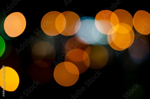 Bokeh of defocused night lights of yellow, red and blue colors on a black background. © Сергей Михайлов