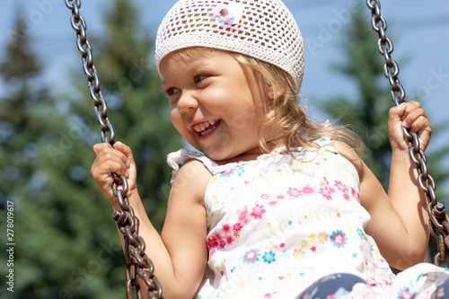 smiling little girl on swing