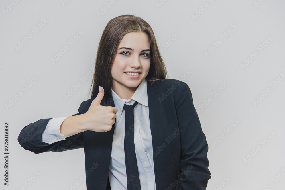 Female hand gestures thumb up. Girl allots her right hand with a raised thumb. Business girl is smiling broadly and shares positive emotions. Female hand gestures thumb up. Girl allots her right hand with a raised thumb. Business girl is smiling broadly and shares positive emotions.