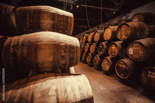 Fotografering Many oak barrels in cellar corridors with port wine winery in darkness