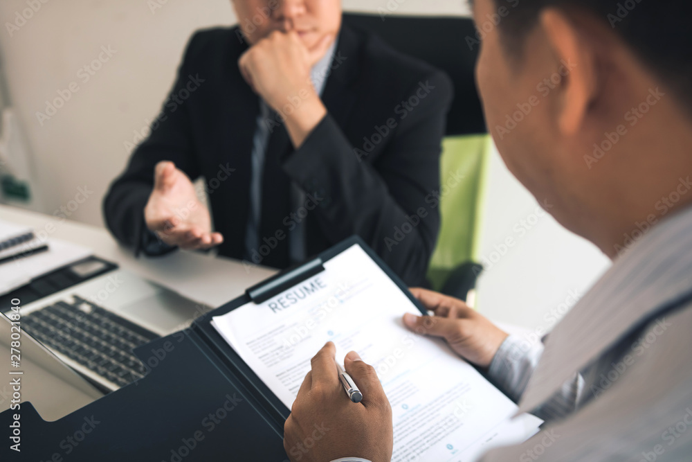 Serious asian businessman important conversation with male employee are reviewing resume documents. Serious asian businessman important conversation with male employee are reviewing resume documents.