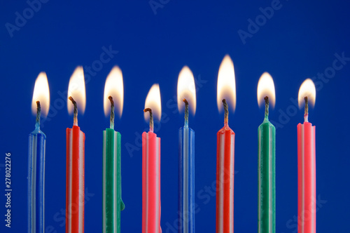 Burning birthday candles on blue background