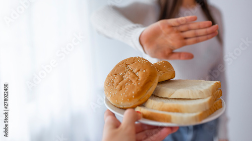 Schilderij op canvas Young woman on gluten free diet is saying no thanks to toast
