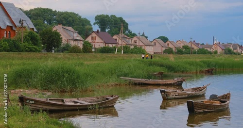 Braslau, Belarus. People Walking Near Lake Coast. Wooden Rowing Fishing Boats In Summer Evening On The Dryvyaty Lake. This Is The Largest Lake Of Braslav Lakes photo