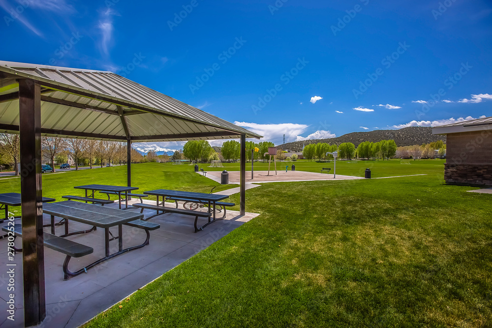 Picnic pavilion with a pathway connected to a water park near a building Picnic pavilion with a pathway connected to a water park near a building