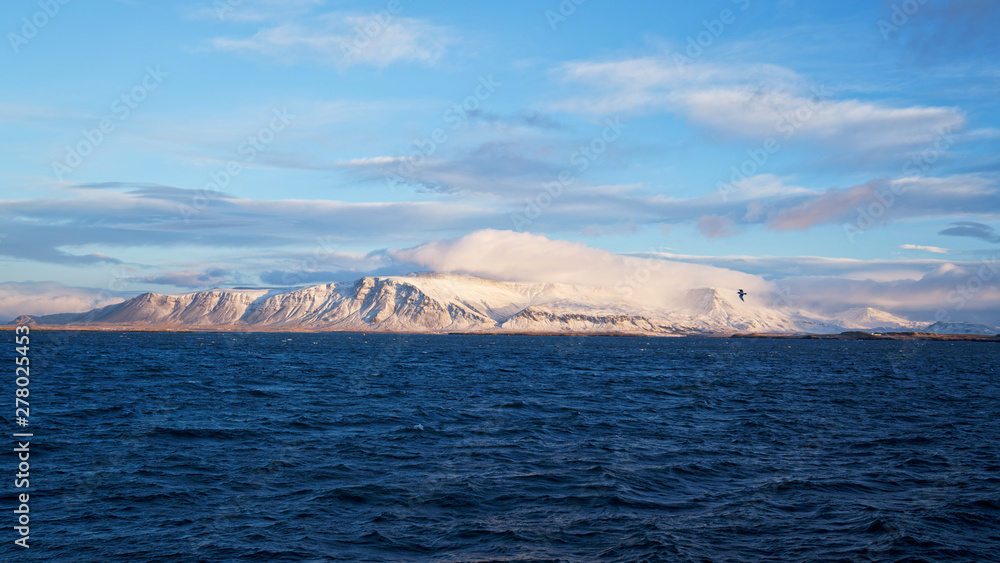 Snowcapped mountain sea view from Reykjavik harbour in Iceland during winter