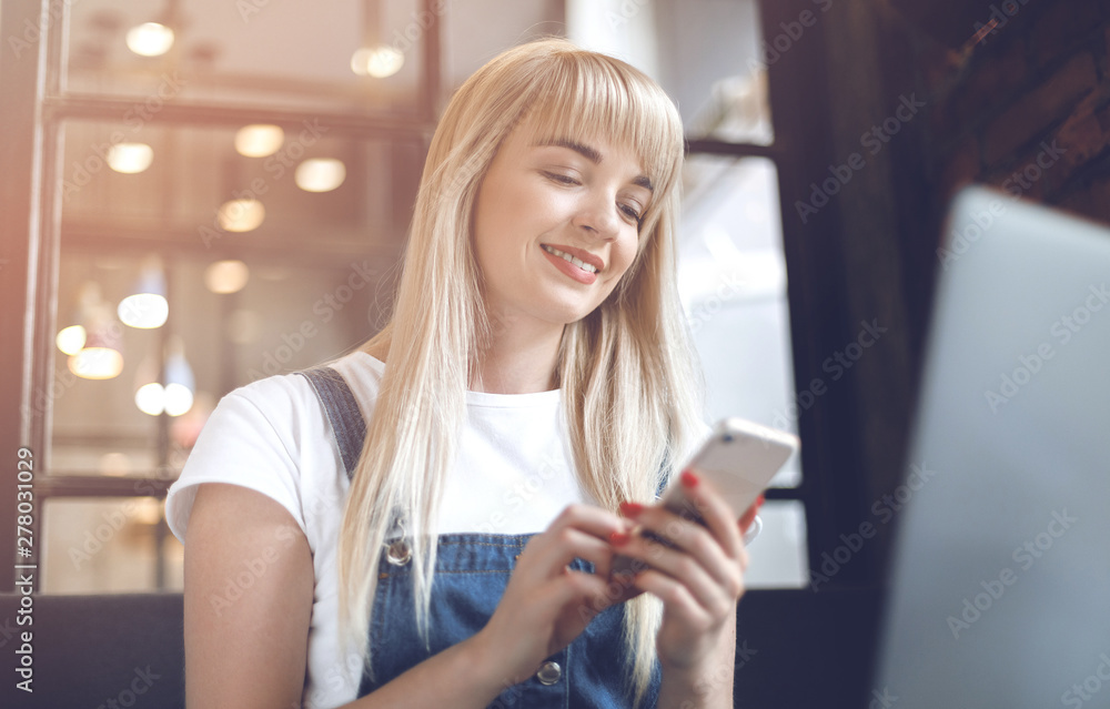 Young girl at cafe drinking coffee and using mobile phone. Online shopping Young girl at cafe drinking coffee and using mobile phone. Online shopping