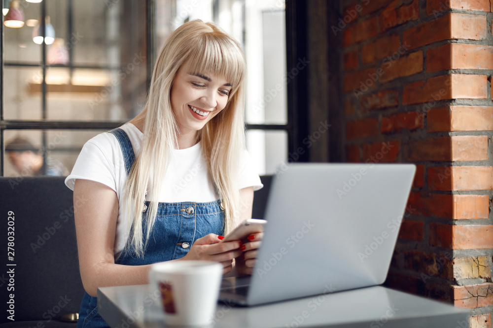 Young girl at cafe drinking coffee and using mobile phone. Online shopping Young girl at cafe drinking coffee and using mobile phone. Online shopping