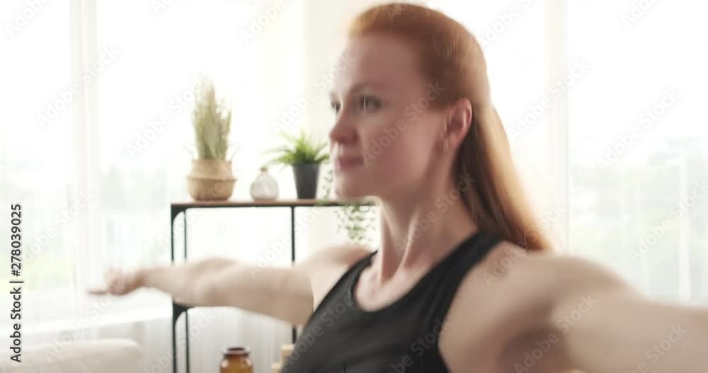 Young sportswoman doing jumping jacks exercise at home Young sportswoman doing jumping jacks exercise at home