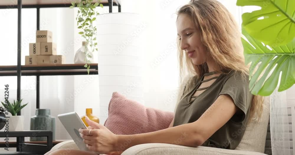 Teenage girl having fun using digital tablet on sofa Teenage girl having fun using digital tablet on sofa