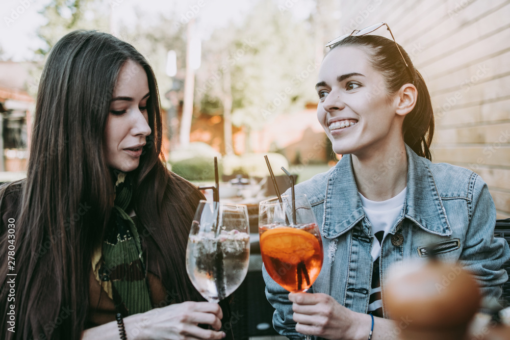 I can tell you everything. Two pretty excited happy young women talking to each other and having dinner cheering with cocktails. I can tell you everything. Two pretty excited happy young women talking to each other and having dinner cheering with cocktails.