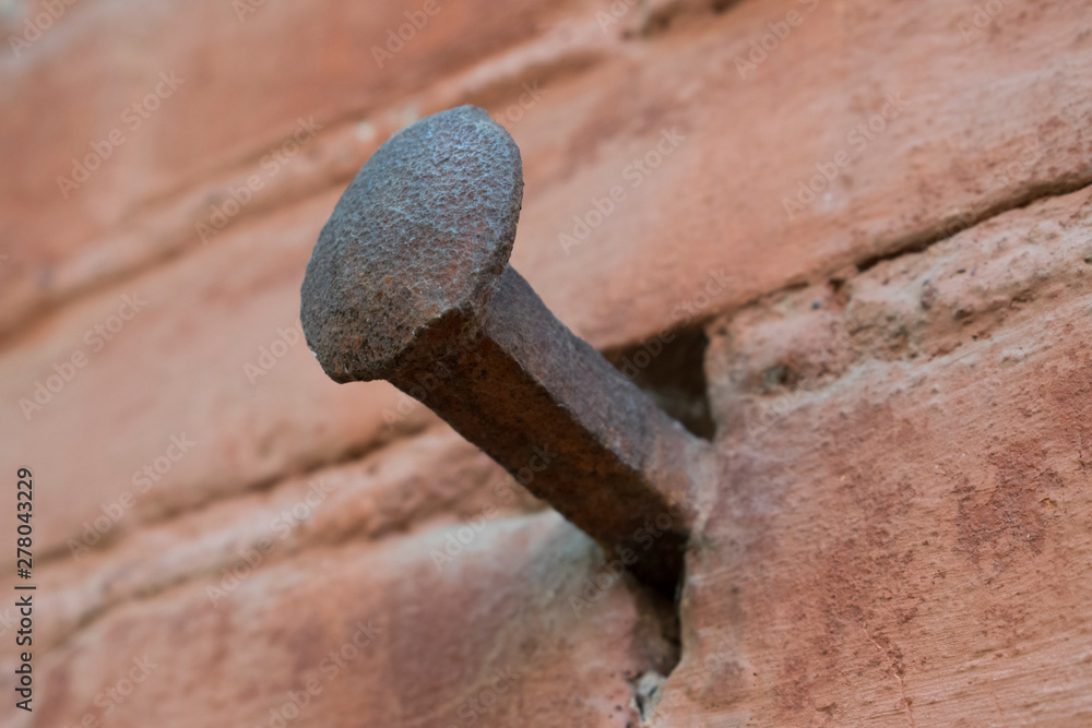 Old forged nail on historical red brick wall. Architecture, detail, macro. Old forged nail on historical red brick wall. Architecture, detail, macro.