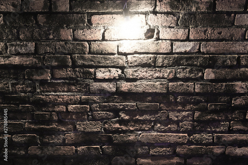 Grungy dark red brick wall with spotlight   texture background.