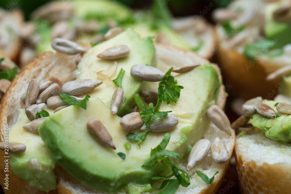 vegan small sandwiches with avocado, parsley and sunflower seeds